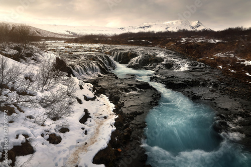Beautiful scenery of Bruarfoss waterfall at southern Iceland where a series of small runlets of water runs into a beautiful, turquoise-blue colored pool. Travel and natural Concept.