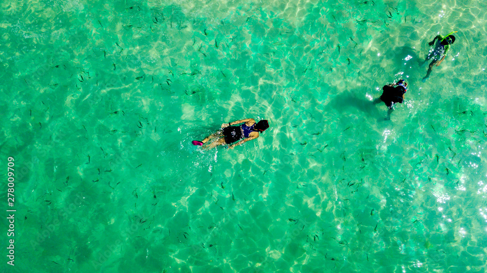 Three people snorkeling in the turquoise water