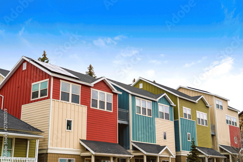 Houses with balconies and porches against blue sky and clouds on a sunny day