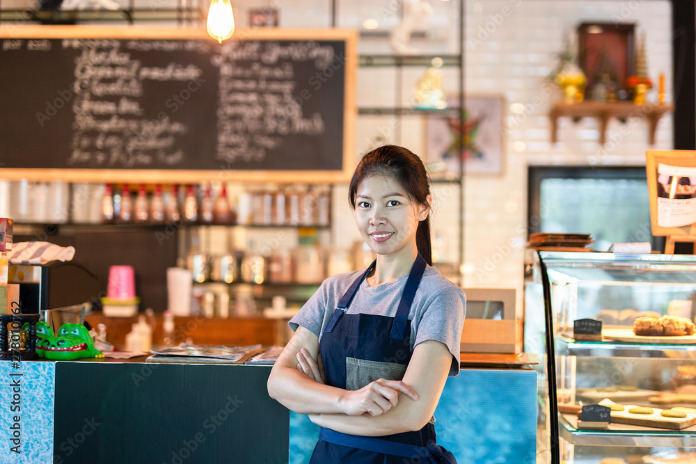 Asian barista woman standing with smile on front of cafe small sme. Asian barista woman standing with smile on front of cafe small sme.