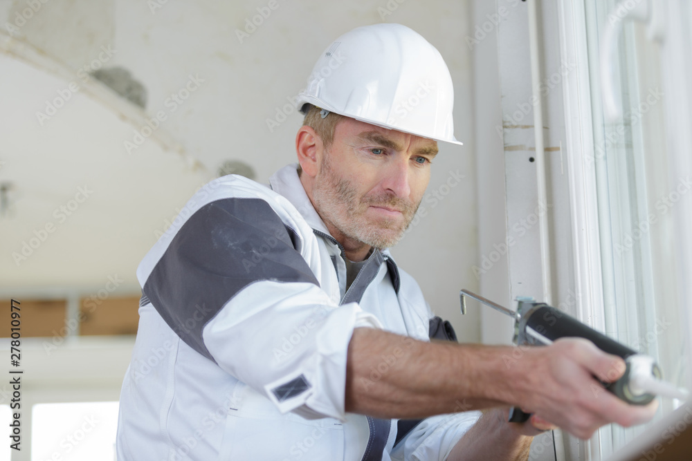 construction worker installing window in house construction worker installing window in house