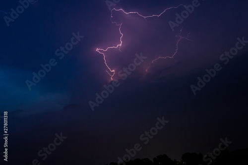 Storm with lightning between the clouds during a summer weather formation.