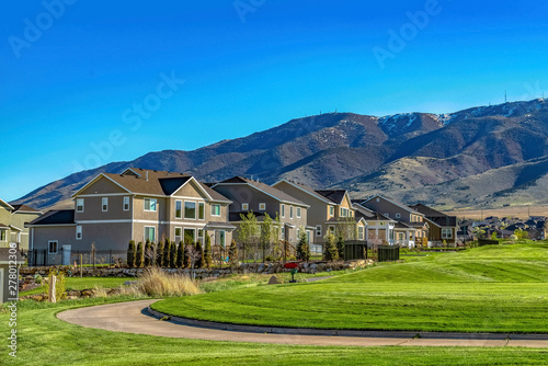 Wallpaper Mural Curving pathway and houses on a valley covered with lush green grasses Torontodigital.ca
