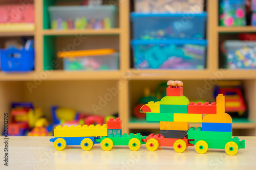 toy train assembled from parts of the designer is on the table . Children's playroom with toys and a coach in the kindergarten photo