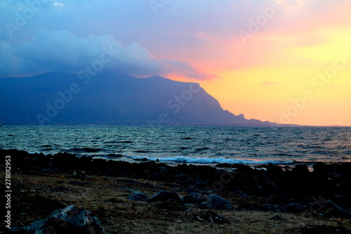 evocative immagine of sunset over the sea with promontory in the background © massimo