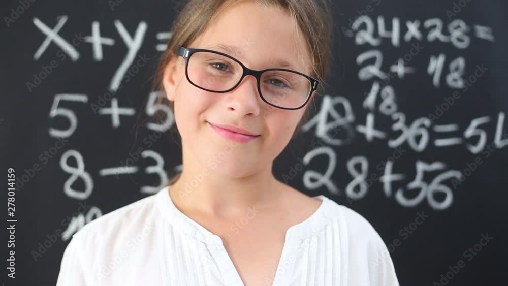 Portrait of a smiling girl with glasses on the background of the school board. Portrait of a smiling girl with glasses on the background of the school board.