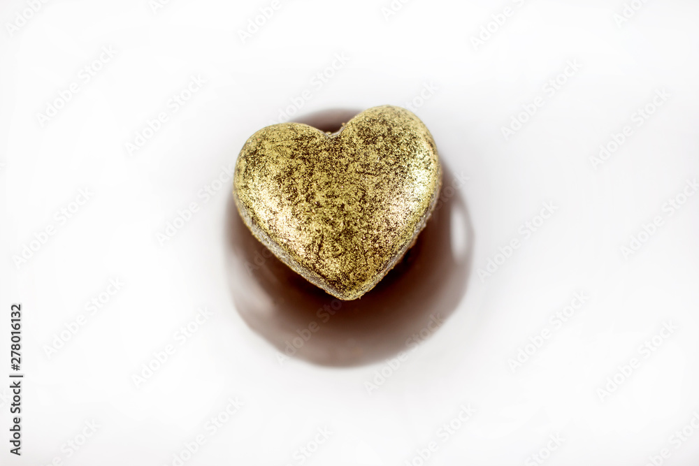 Chocolate candy stuffed with heart covered with gold edible ink as decoration. Chocolate candy stuffed with heart covered with gold edible ink as decoration.