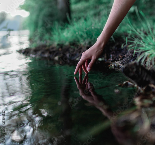 reflection of a girl's hand in a clean  water