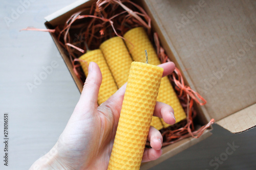 Handmade wax candle on light background.  Christmas decoration for holidays.  Craft and eco concept