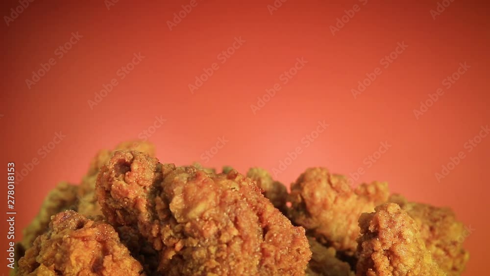 Hand picking fried chicken or crispy kentucky on brown background. Delicious hot meal with fast food.