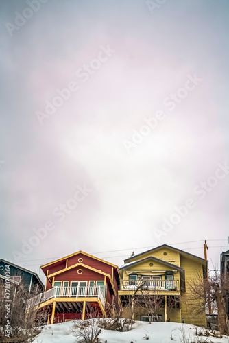 Vast cloudy sky over colorful houses and snow covered ground in winter