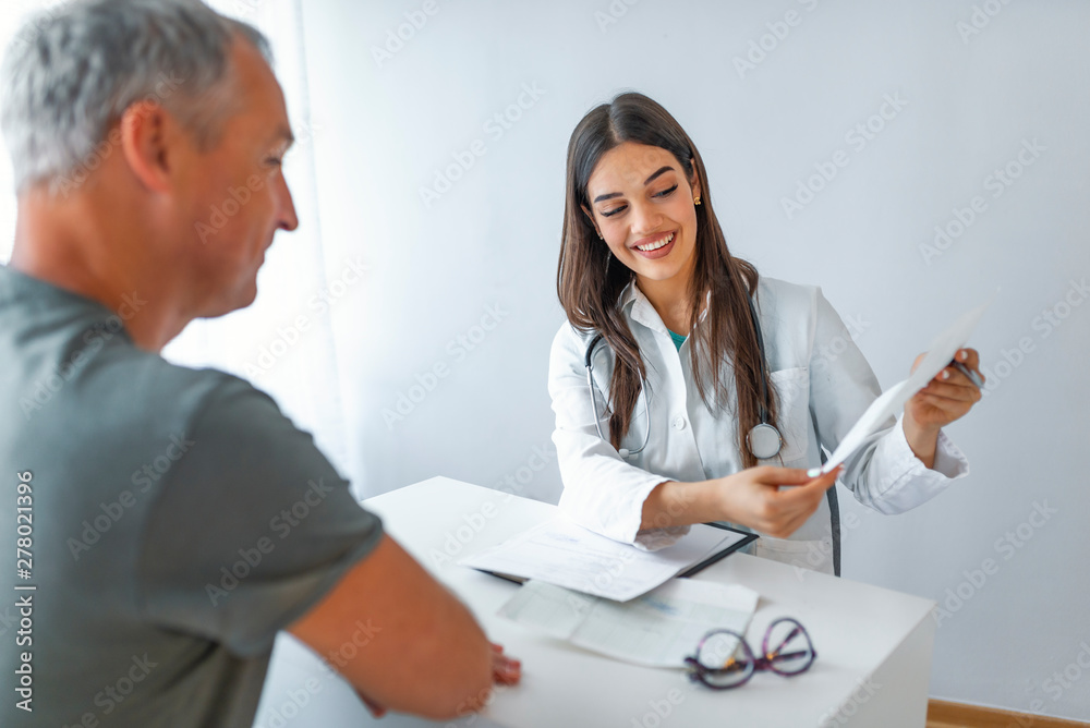 Doctor and patient discussing. Doctor explaining diagnosis to her male patient. Patient Having Consultation With Female Doctor In Office. Doctor and patient sitting in doctor's office Doctor and patient discussing. Doctor explaining diagnosis to her male patient. Patient Having Consultation With Female Doctor In Office. Doctor and patient sitting in doctor's office