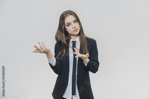 Concentrated business woman opens slightly her mouth and is showing something with her hands. Copy space opportunity. photo