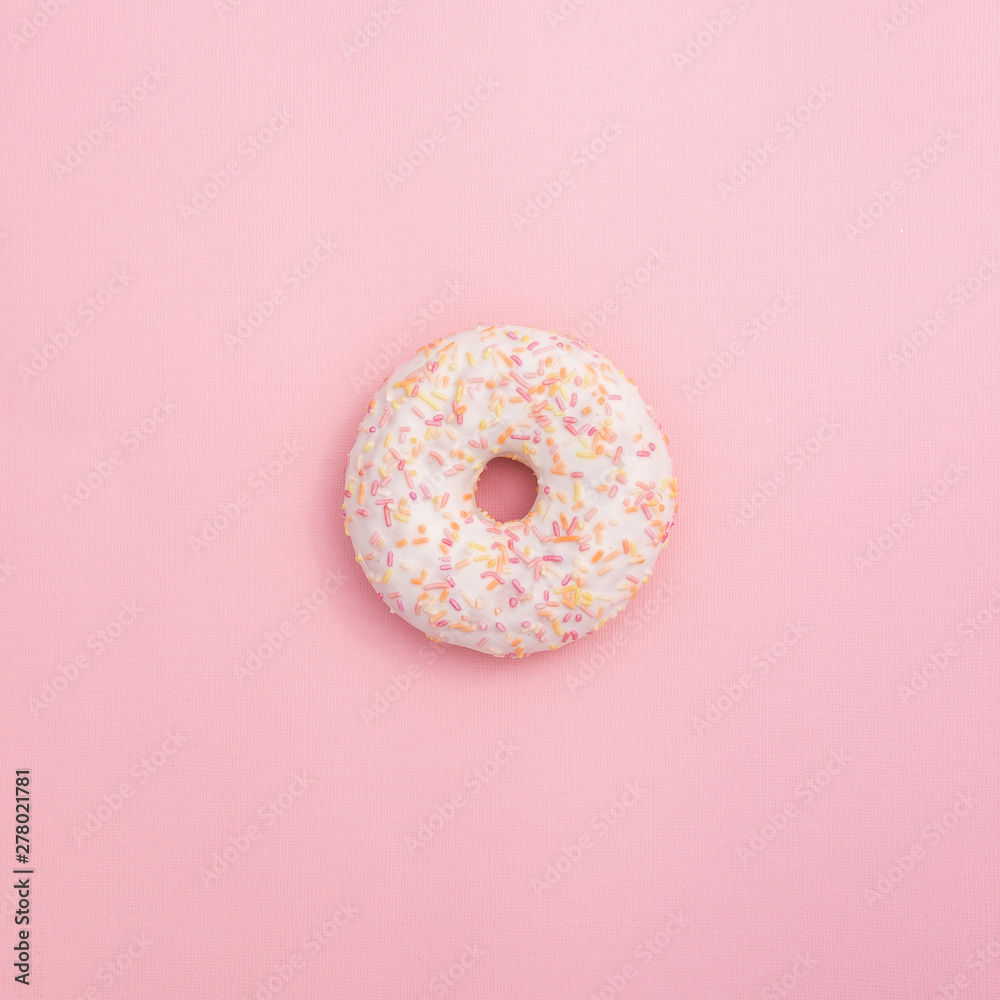 Delicious donut with icing and candy on a pink background. Square lighting background.