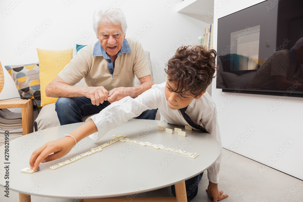 Φωτογραφία GRAND PERE JOUANT AU JEU DES DOMINOS AVEC SON PETIT FILS