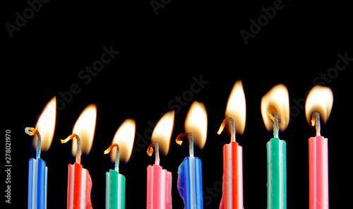 Burning birthday candles on black background