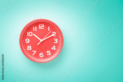 Top view flat lay red alarm clock on green background with copy space