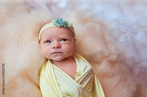 Portert of a beautiful newborn baby girl with a headband. Close-up photo