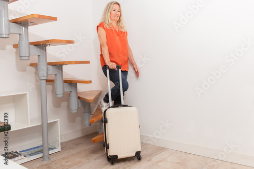 Canvas Print FEMME SENIOR DESCENDANT UN ESCALIER AVEC SA VALISE