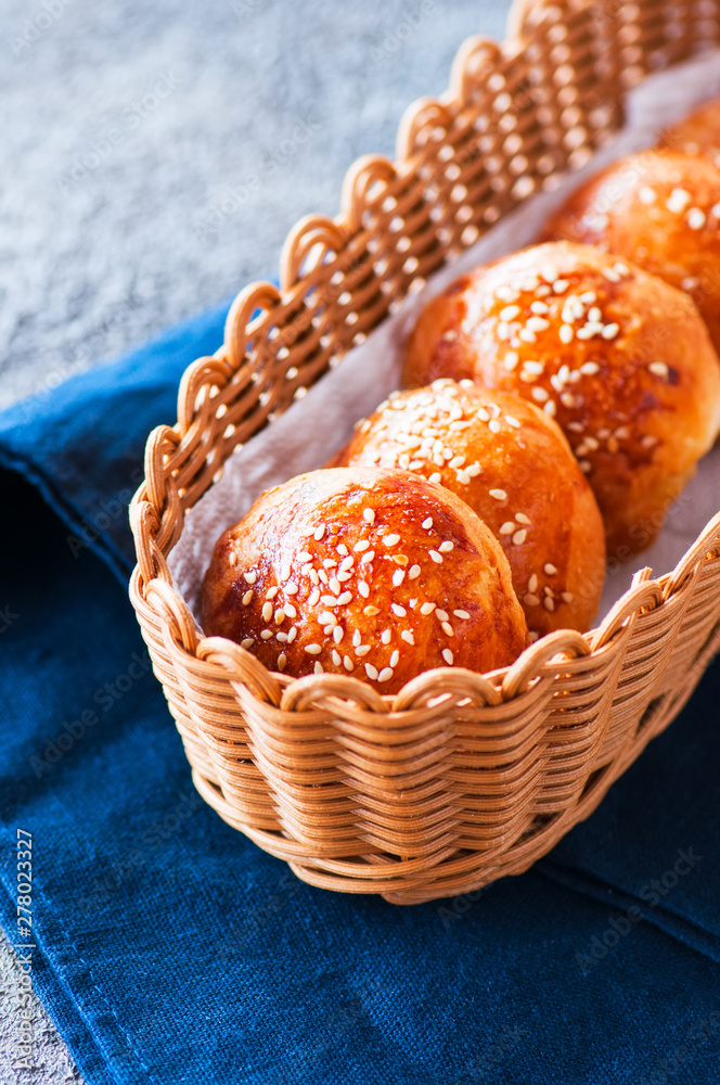 Fotografie Homemade burger buns with sesame seeds in a basket.