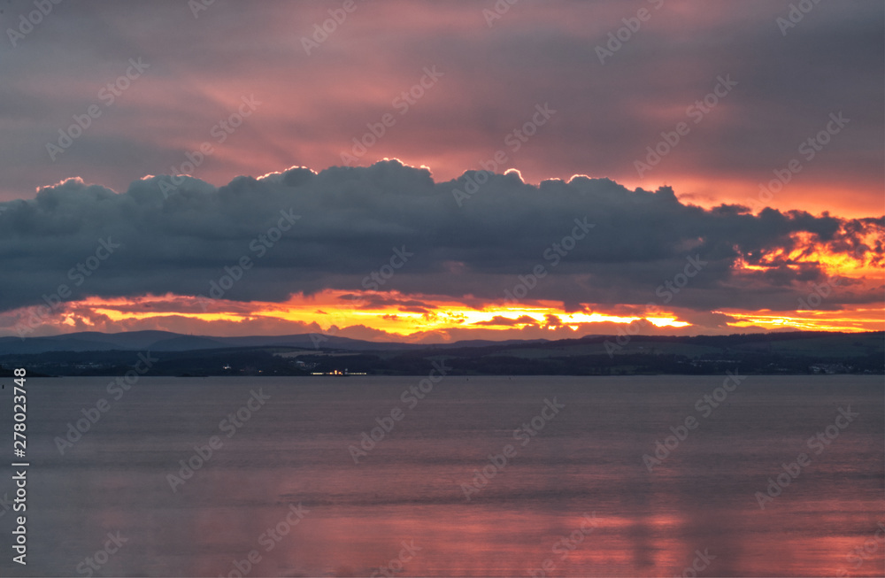 A beautiful landscape picture of a sunset over the Firth of Forth near Edinburgh in Scotland, United Kingdom 