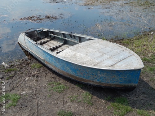 Fototapeta Naklejka Na Ścianę i Meble -  Fishing metal boat on the banks of the river. Old aluminum boat.