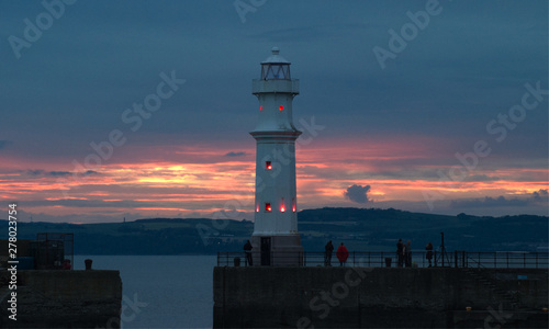 The lighthouse at Newhaven Harbour at sunset in the summer