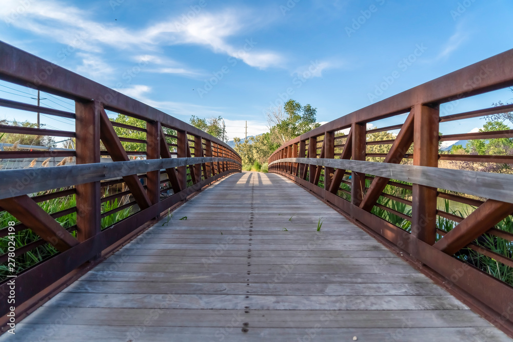 Close up of bridge overlooking trees mountain and blue sky on a sunny day Close up of bridge overlooking trees mountain and blue sky on a sunny day