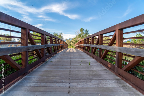 Close up of bridge overlooking trees mountain and blue sky on a sunny day