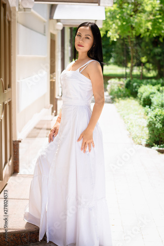 Portrait of woman in white dress on park