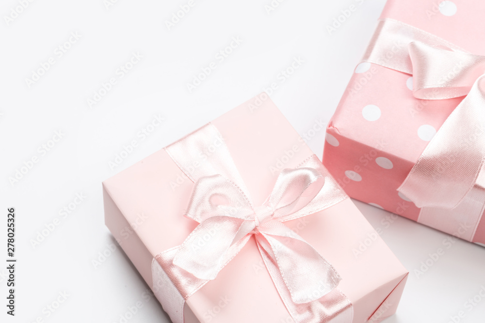 Gift box wrapped in pastel  paper with pink ribbon isolated on white background - obrazy, fototapety, plakaty 