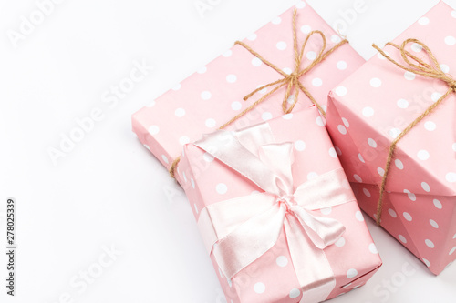 Gift box wrapped in pastel paper with pink ribbon isolated on white background