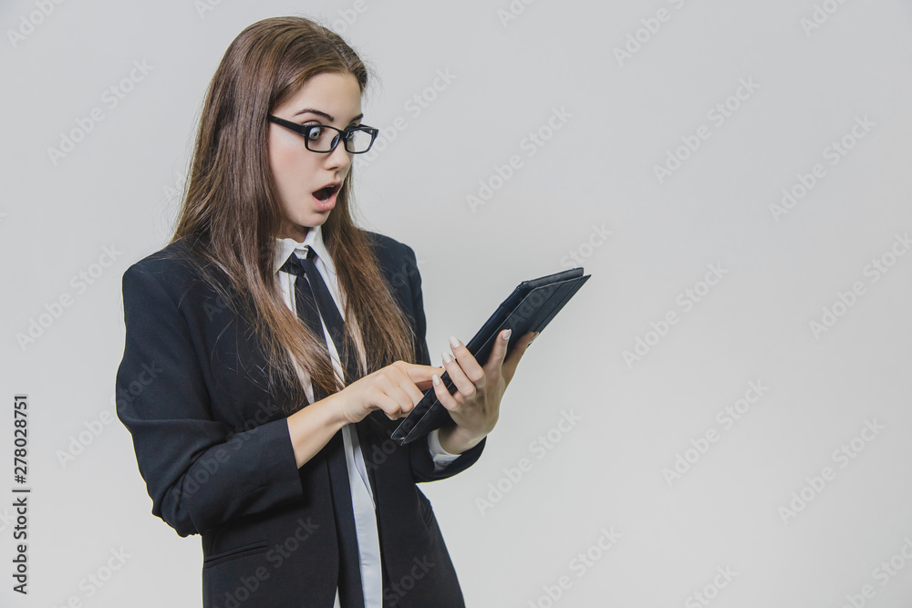Attractive business woman is looking at the iPad, tablet being shocked, isolated on white background. Attractive business woman is looking at the iPad, tablet being shocked, isolated on white background.