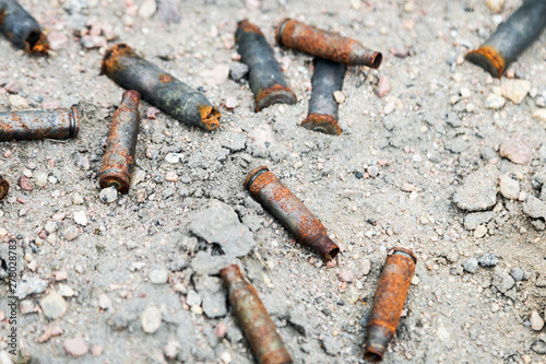 lots of old rusty gun casings on the ground.