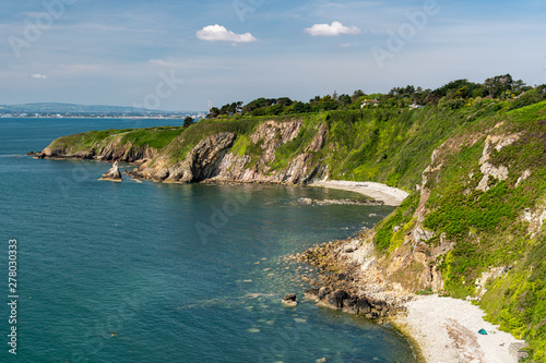Photography View from the popular hiking coastal trail Howth Cliff Walk in county Dublin, Ireland on a sunny summer day with blue Irish Sea clear waters and stunning wild beaches and green cliffs