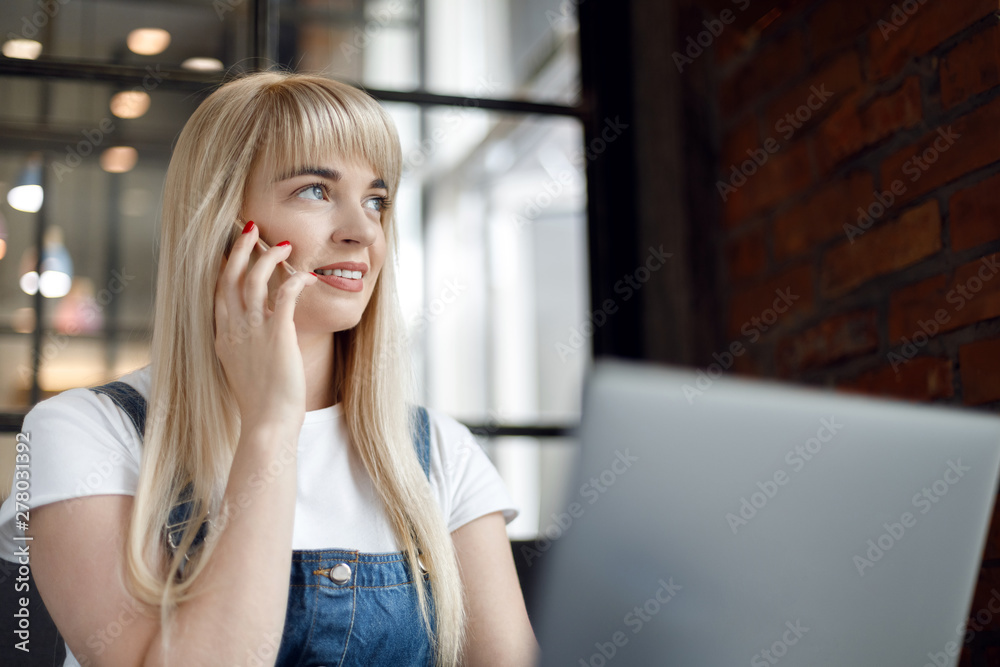 Young girl at cafe drinking coffee and using mobile phone. Online shopping
