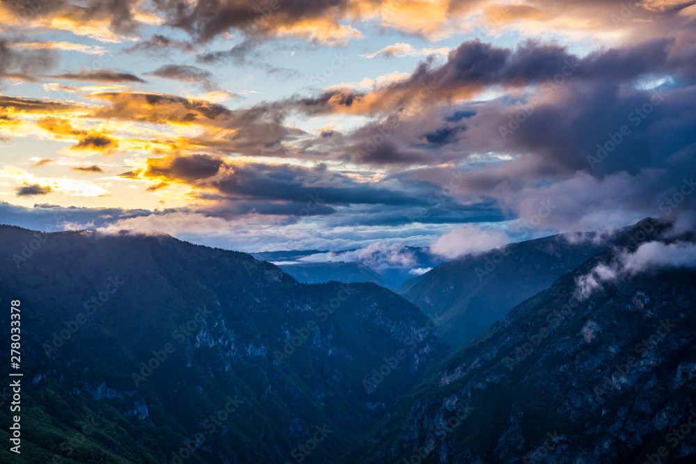 Montenegro, Tara river canyon nature landscape from aerial perspective decorated with colorful sunset sky and glowing clouds shining over majestic national park near zabljak