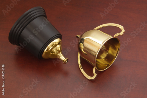 Foto Broken golden champion trophy cup on wooden background, loose and unlucky concep