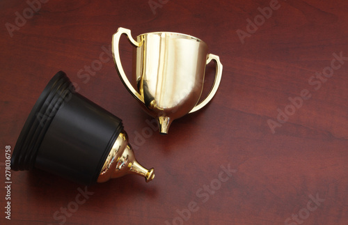 Obraz na plátně Broken golden trophy cup on wooden background, loose and unlucky concept