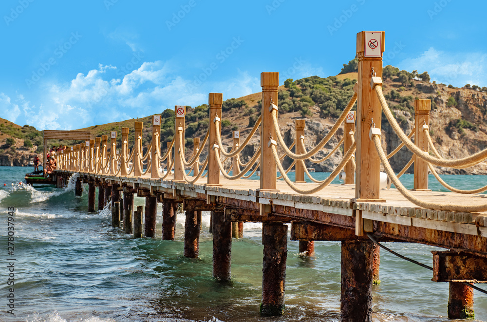 Obraz premium Scene at Tropical Beach Resort with wooden pier and rope