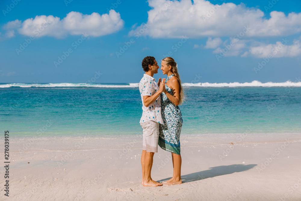 Beautiful pregnant woman with husband expecting baby at tropical beach with blue ocean Beautiful pregnant woman with husband expecting baby at tropical beach with blue ocean