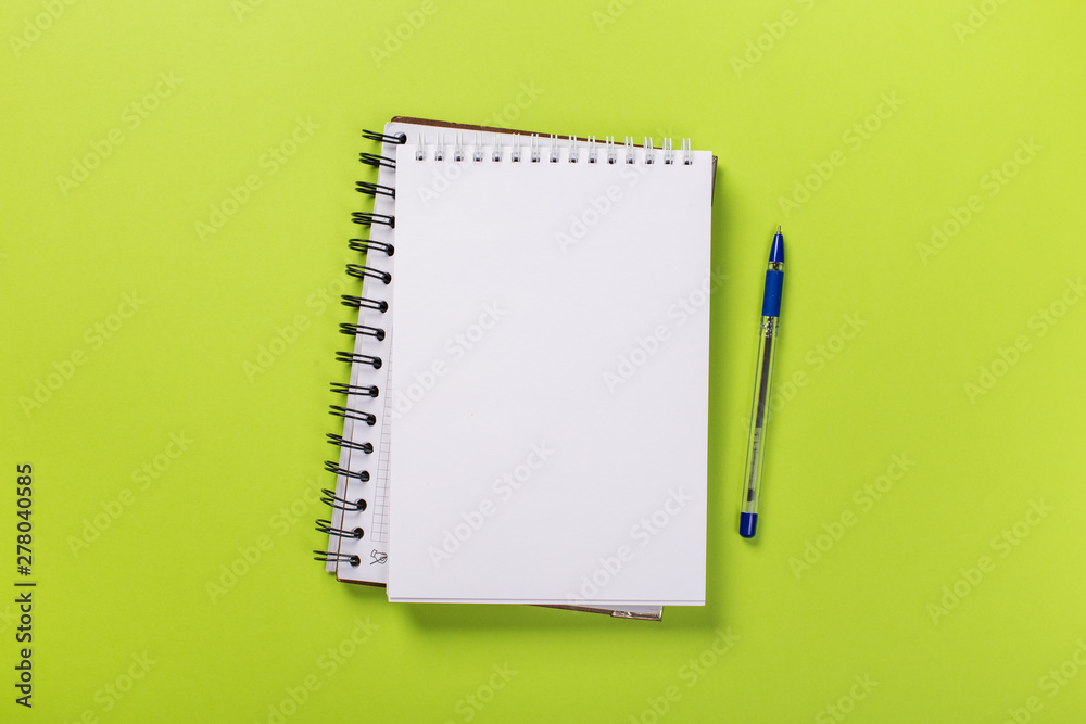 school notebook on a green background, spiral notepad on a table. school notebook on a green background, spiral notepad on a table.