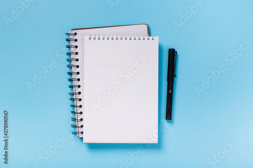 school notebook on a blue background, spiral notepad on a table