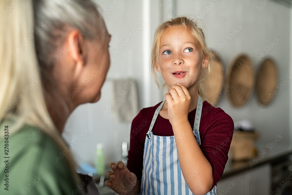 Cute girl tasting cookie dough