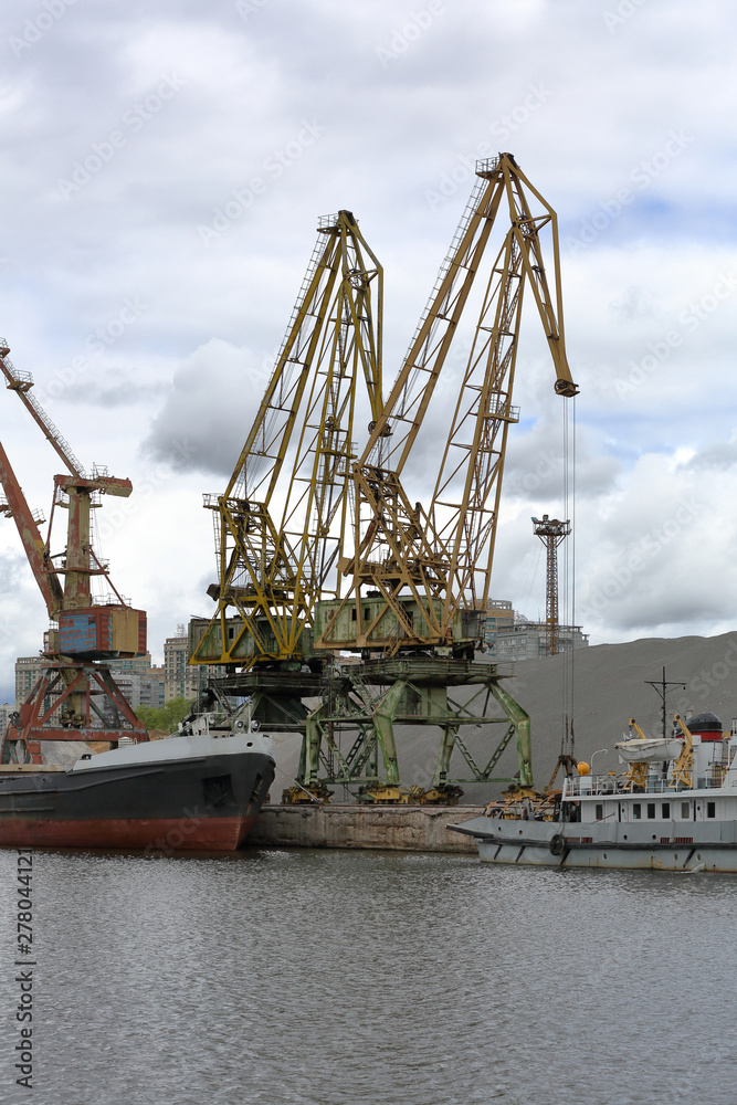 Fototapeta premium Industrial crane for unloading and loading in the river port