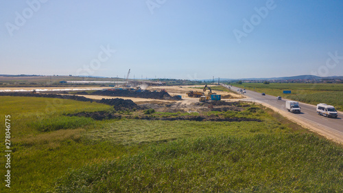 Aerial Road Building Site. Flight Over Construction Crews And Heavy Equipment photo