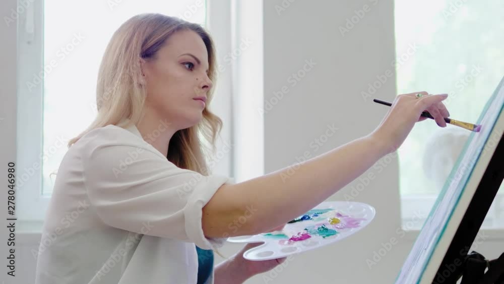 Creative painter paints a colorful picture in her studio