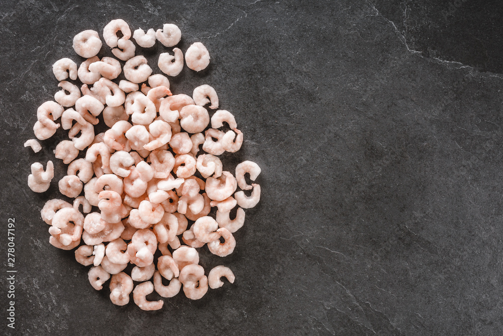 Fresh red shrimps or frozen prawn on slate stone background. Seafood, top view, flat lay, copy space Fresh red shrimps or frozen prawn on slate stone background. Seafood, top view, flat lay, copy space