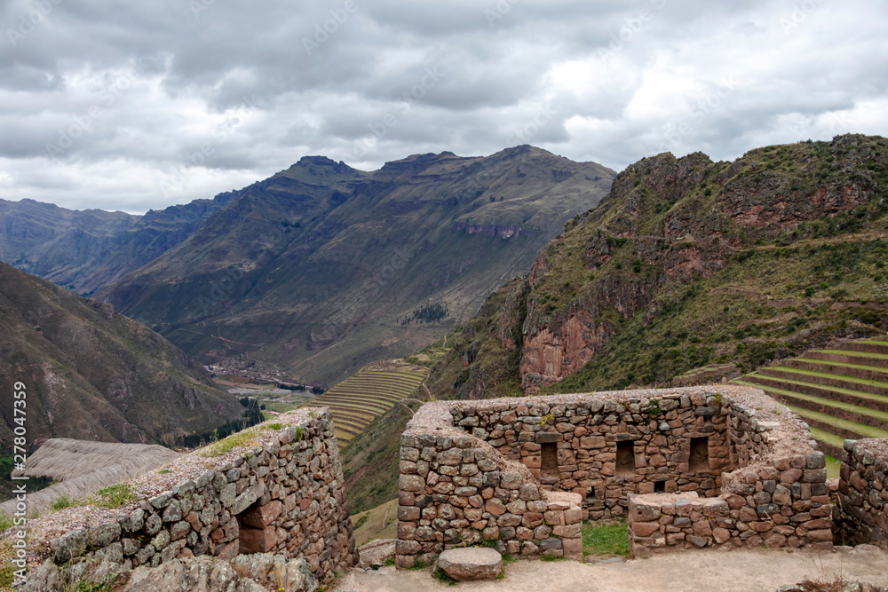 Inca ruins in Pisac archeological site and green peruvian Andes mountains, Sacred valley of the Incas, Peru