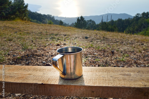 Cup with a hot tea over Beautiful view on mountain and field in summer